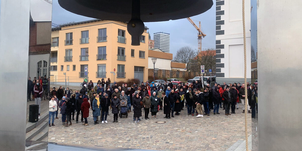 Menschen die im Februar 2022 Solidarität mit der Ukraine an der Frankfurter Friedensglocke zeigen.