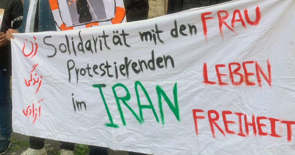 Die Männer, die dieses Banner halten, zeigen sich solidarisch mit den protestierenden Frauen im Iran.