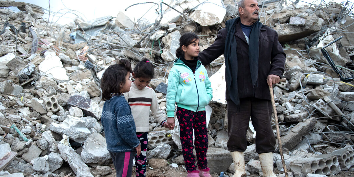 Überlebenden auf den Trümmern ihrer Häuser in der Türkei.