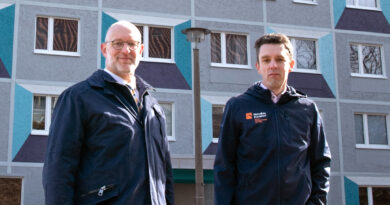Olaf Runge und Dirk Oeltjen vom Vortsand der WohnBau Frankfurt vor dem gerade sanierten Wohnhaus Dr.-Salvador-Allende-Höhe.