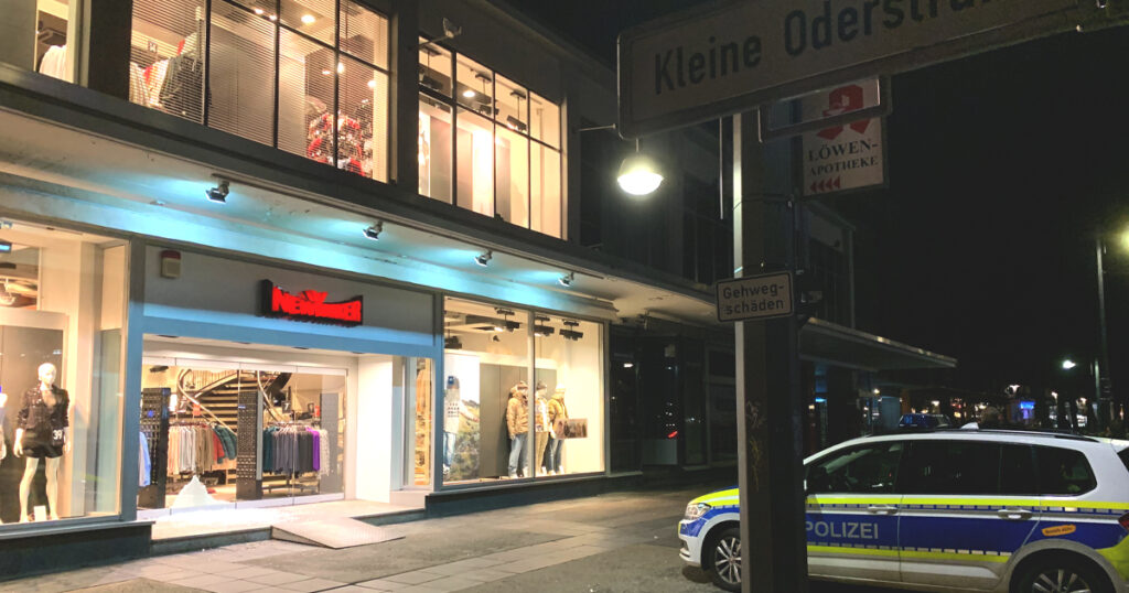 Polizei hält Wache vor den zerschalgenen Scheiben in der Karl-Marx-Straße.